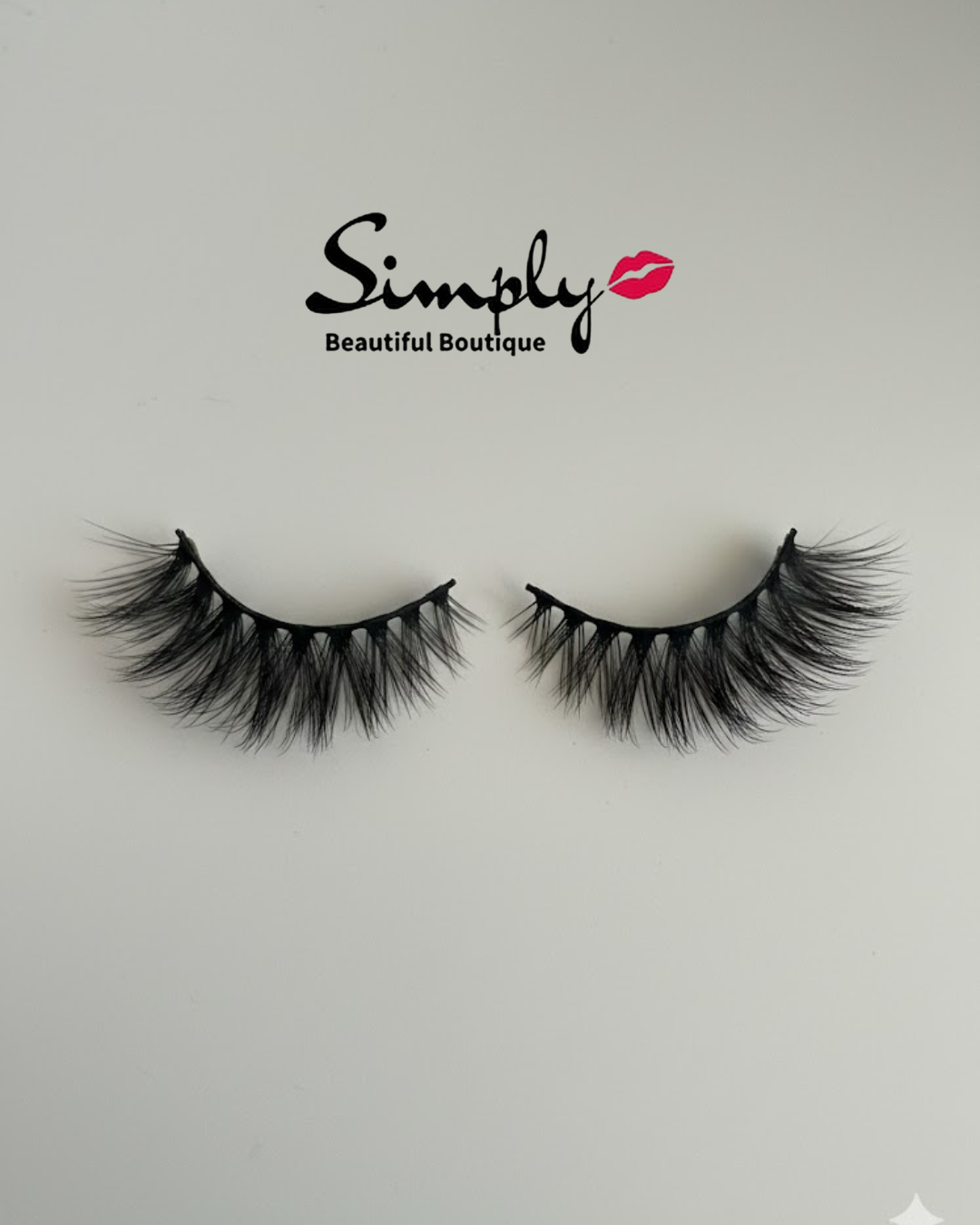 Heartbreak Glam Strip Lashes. Pair of false eyelashes with 'Simply Beautiful Boutique' logo on a light gray background